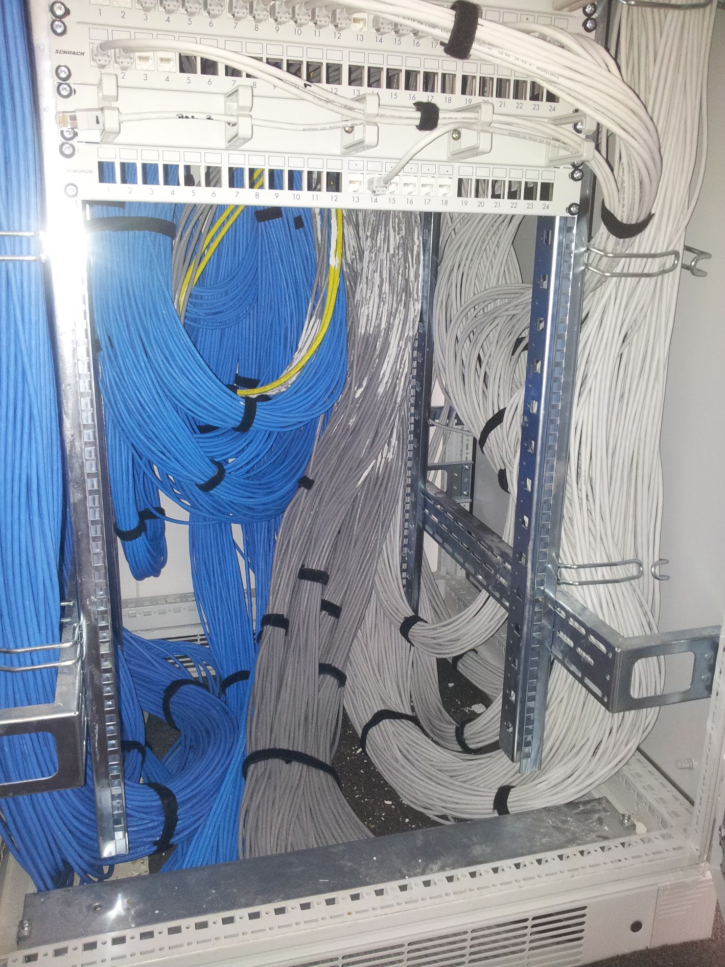 Interior de rack cu cabluri albastre și albe organizate pe trasee separate